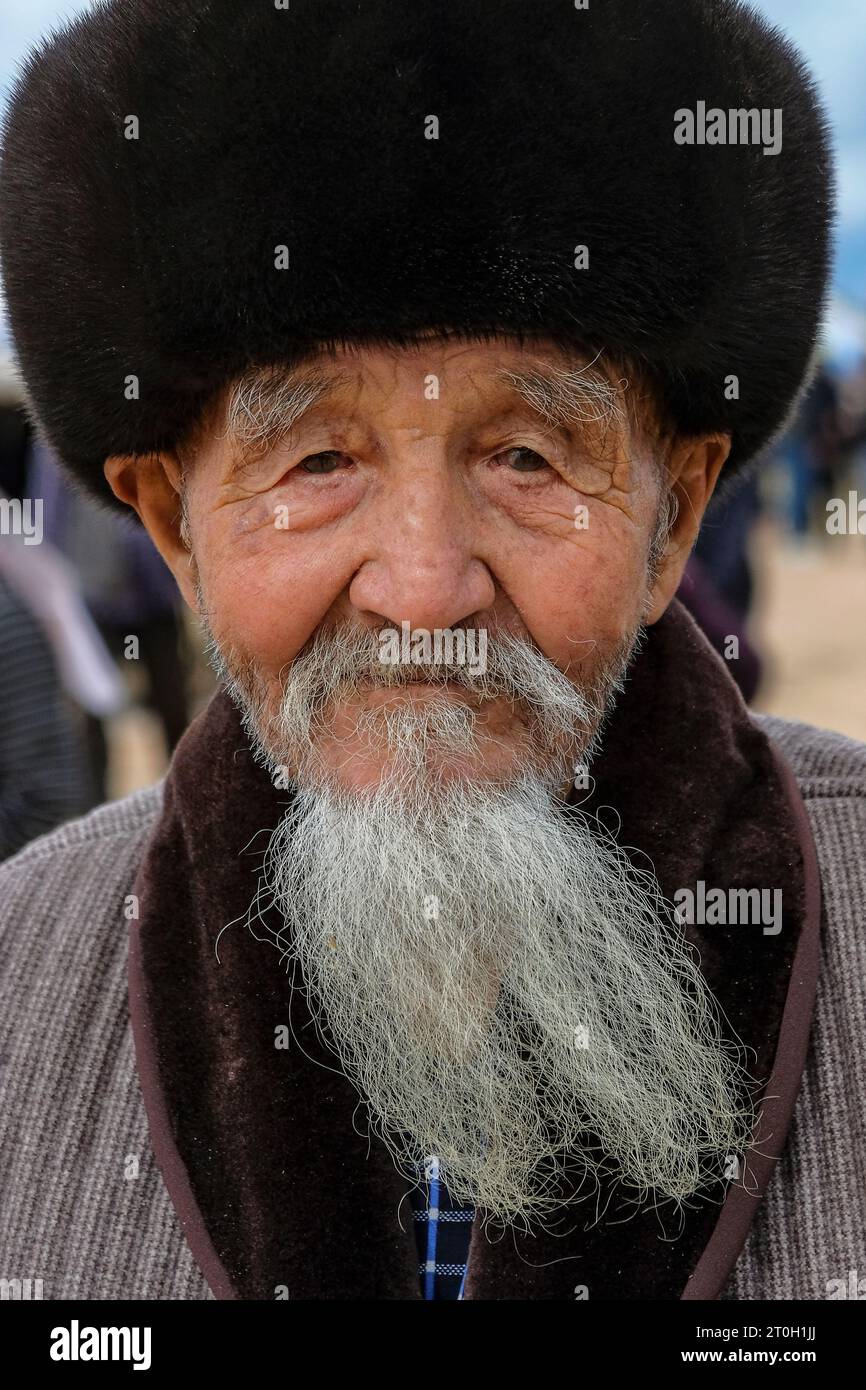 Bokonbayevo, Kirgisistan - 22. September 2023: Porträt eines älteren Mannes mit Bart und Hut in Bokonbayevo, Issyk Kul Lake, Kirgisistan. Stockfoto