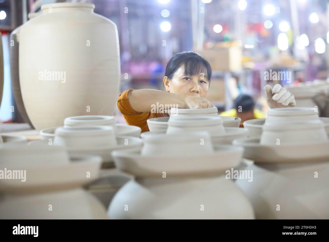 CHONGQING, CHINA - 7. OKTOBER 2023 - Ein Arbeiter färbt am 7. Oktober 2023 in Chongqing, China ein Weinglas mit Blumen in einer Keramikwerkstatt. Stockfoto