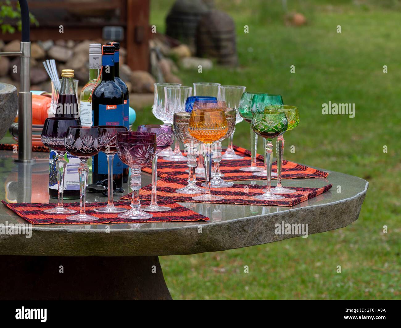 Römische Bleikristall-Gläser, Weingläser, Champagnergläser, farbenfroh auf Partytisch im Garten Stockfoto