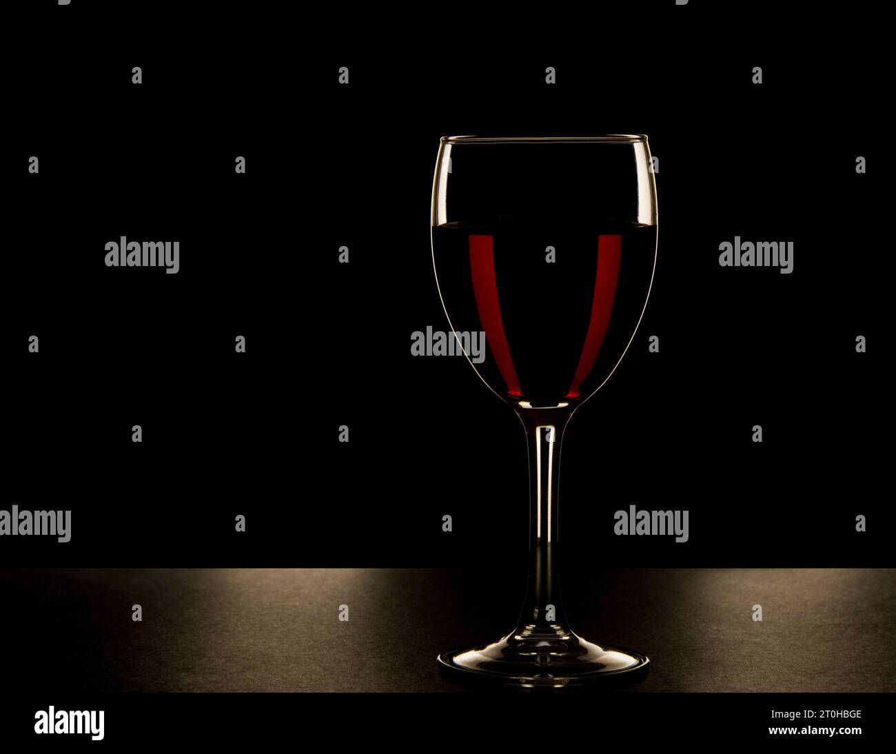 Ein Glas Rotwein, Moody, friedlich und hintergrundbeleuchtet. Stockfoto