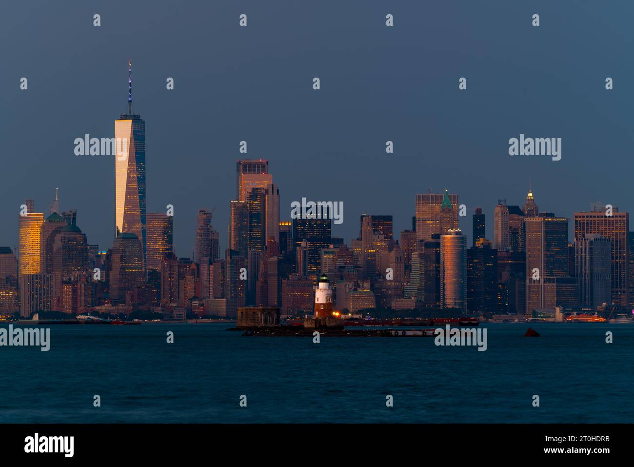 Stadtlandschaft zur blauen Stunde über New York. Einschließlich des robbins Reef Leuchtturms. New York Wolkenkratzer sind im Hintergrund einschließlich WTC. Stockfoto