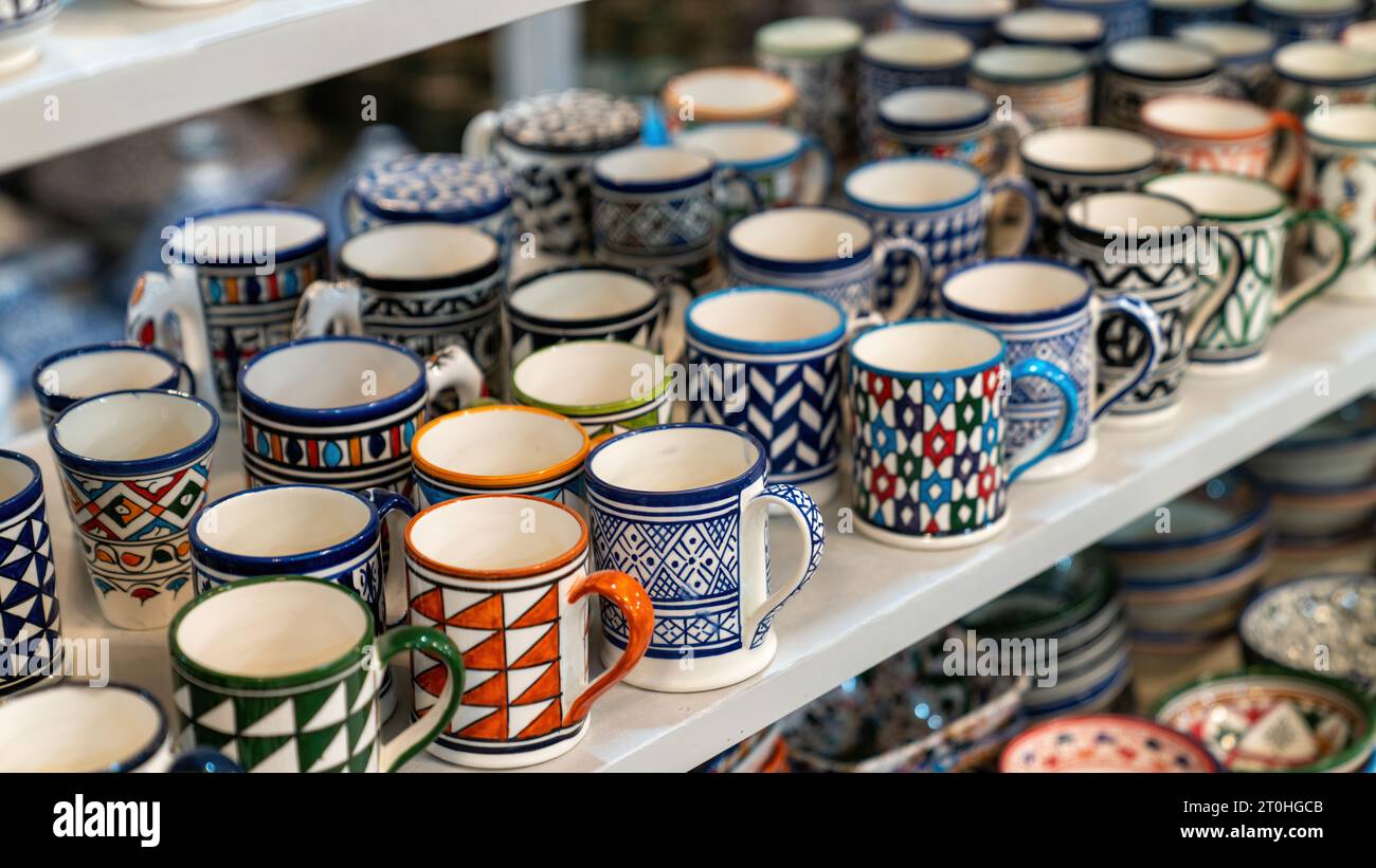 Marokkanische Tassen mit farbenfroher Keramik und Töpferwaren werden vor Geschäften in den Souks oder traditionellen Märkten ausgestellt. Stockfoto