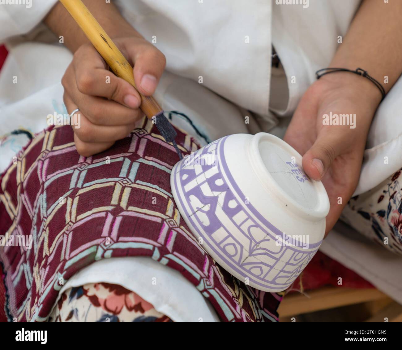 Fes, Marokko - 10. September 2022: Handwerker malen und dekorieren farbenfrohe Keramikprodukte in der Töpferei Stockfoto