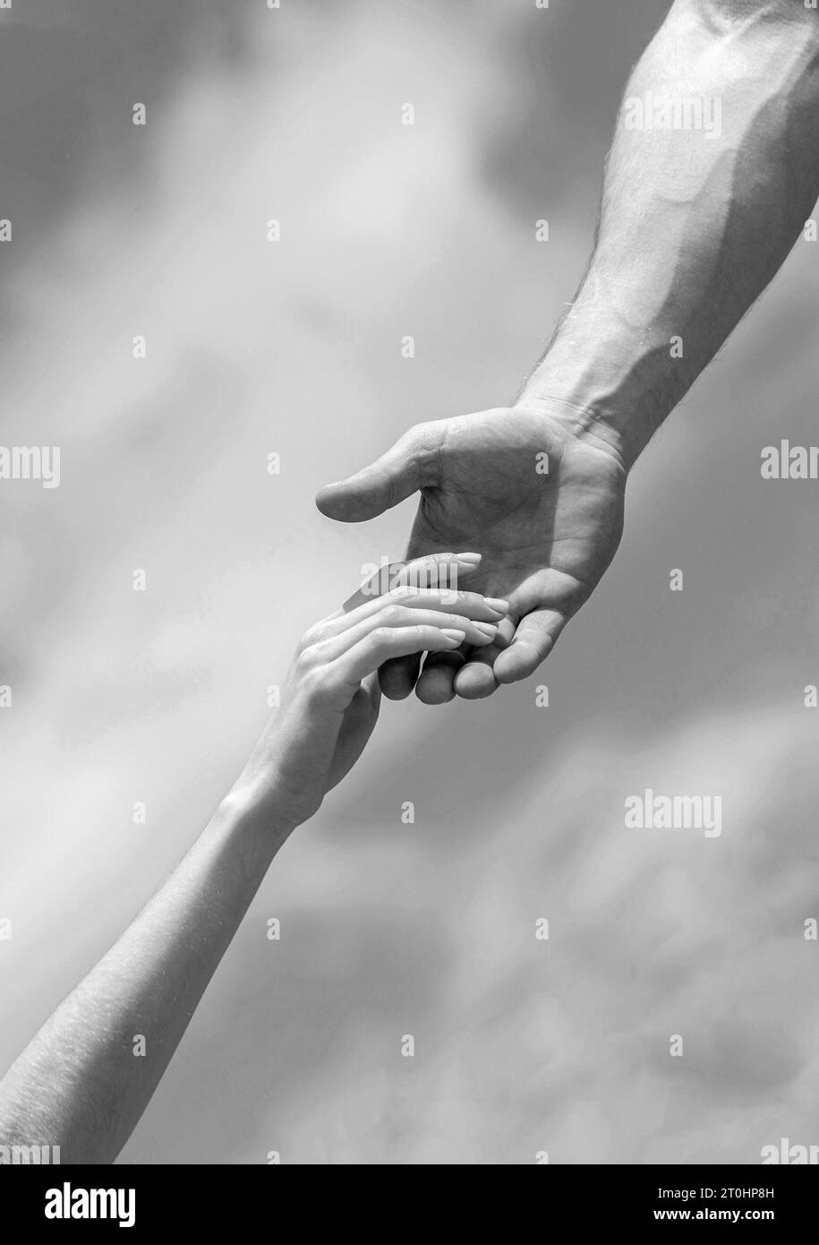 Eine helfende Hand geben. Hände von Mann und Frau auf blauem Himmel Hintergrund. Eine helfende Hand geben. Solidarität, Mitgefühl und Nächstenliebe, Rettung Stockfoto