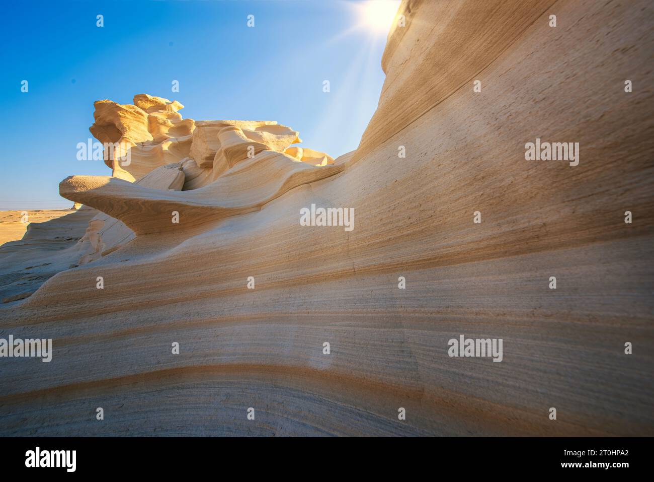 Wüste erodierte Felsmuster mit klarem Himmel und Sonne. Wüstengesteinsformation mit Erosion Stockfoto