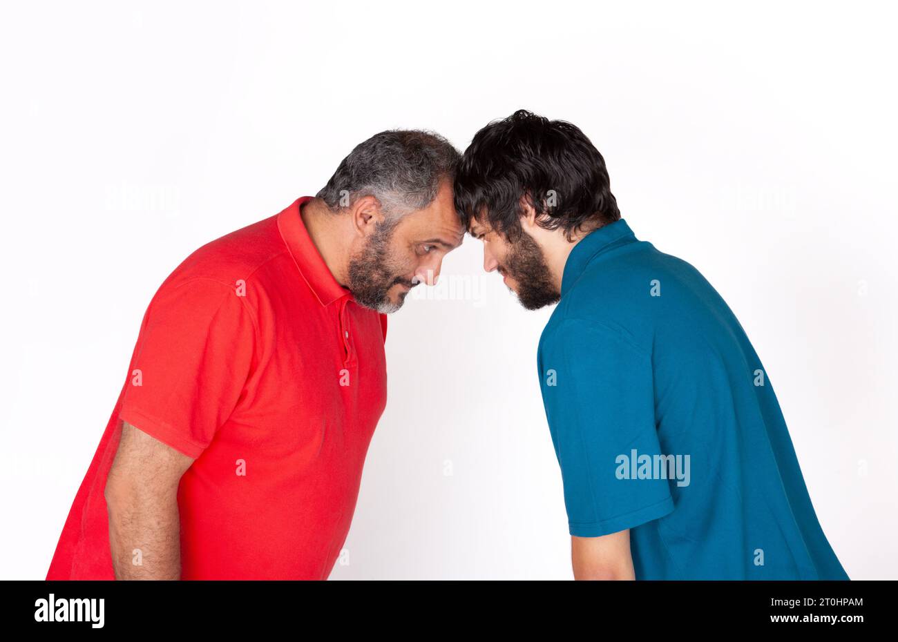 Zwei unrasierte Männer stehen Kopf an Kopf gegenüber auf weißem Hintergrund Stockfoto