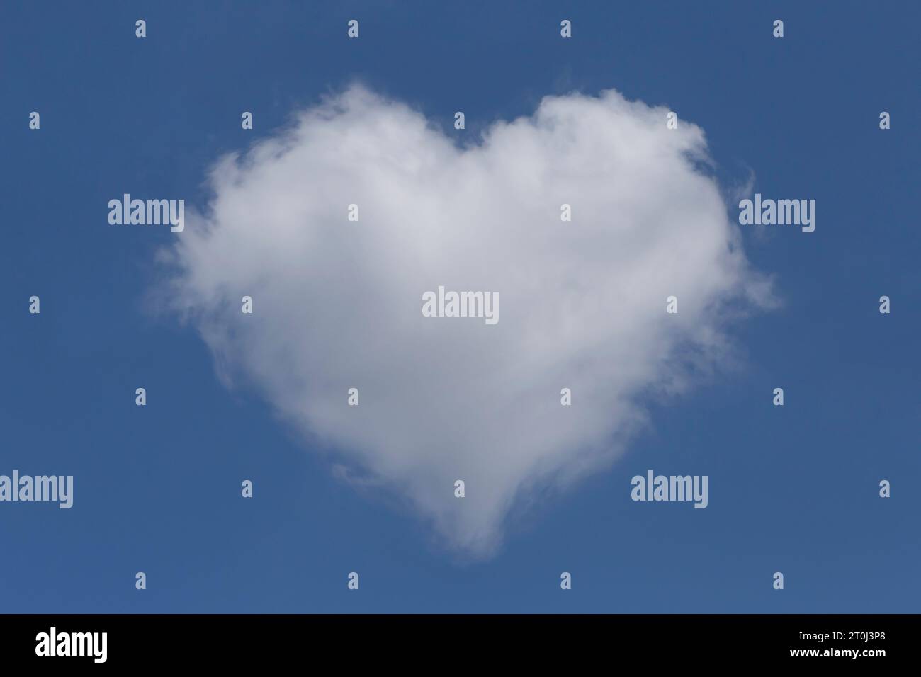 Weiße flauschige valentinswolke an einem klaren blauen Himmel Stockfoto