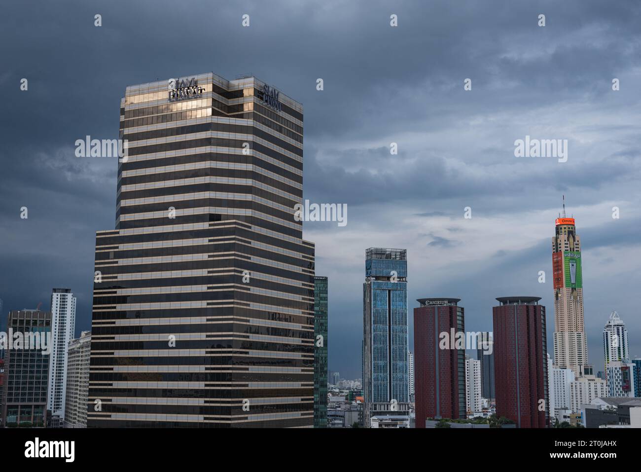 Bangkok, Thailand - 16. September 2023: Siam Piwat Tower und andere Wolkenkratzer der Innenstadt vor dem abendlichen bewölkten Himmel. Stockfoto
