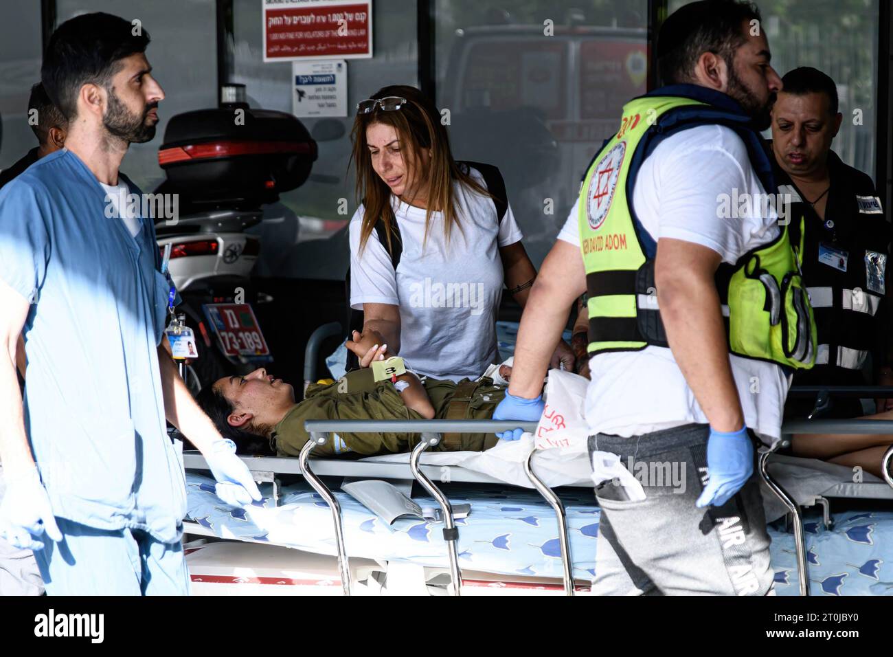 Tel Aviv, Israel. Oktober 2023. Eine Frau hält die Hand eines verwundeten Soldaten, der nach einer Invasion der Hamas in israelische Siedlungen rund um den Gazastreifen am Noteingang des Ichilov-Krankenhauses in Tel Aviv ankam. Quelle: SOPA Images Limited/Alamy Live News Stockfoto