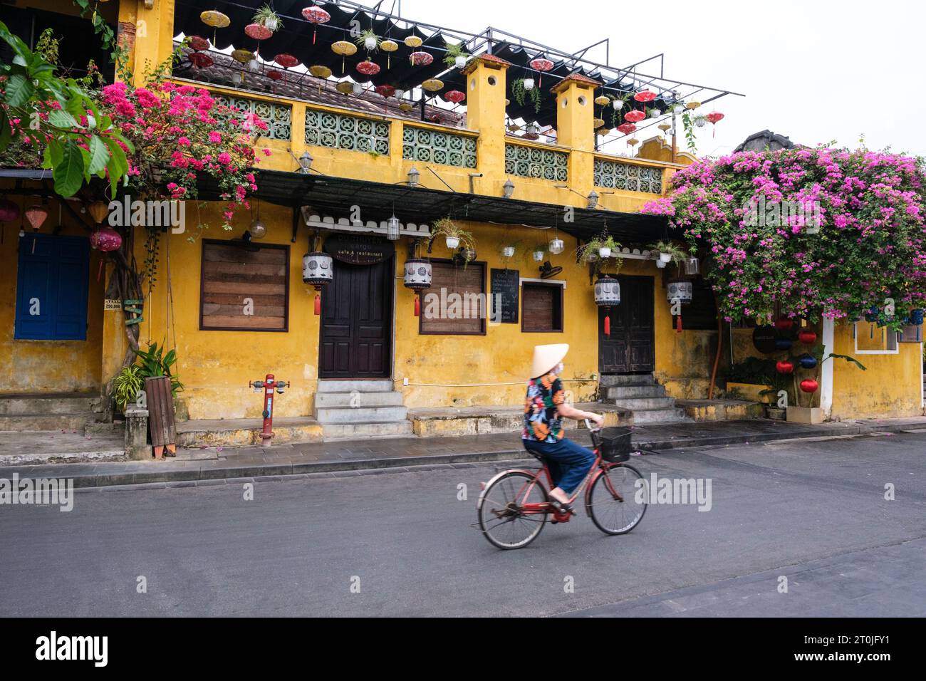 Hoi An, Vietnam. Am frühen Morgen Straßenszene, Frau reitet zum Markt. Stockfoto