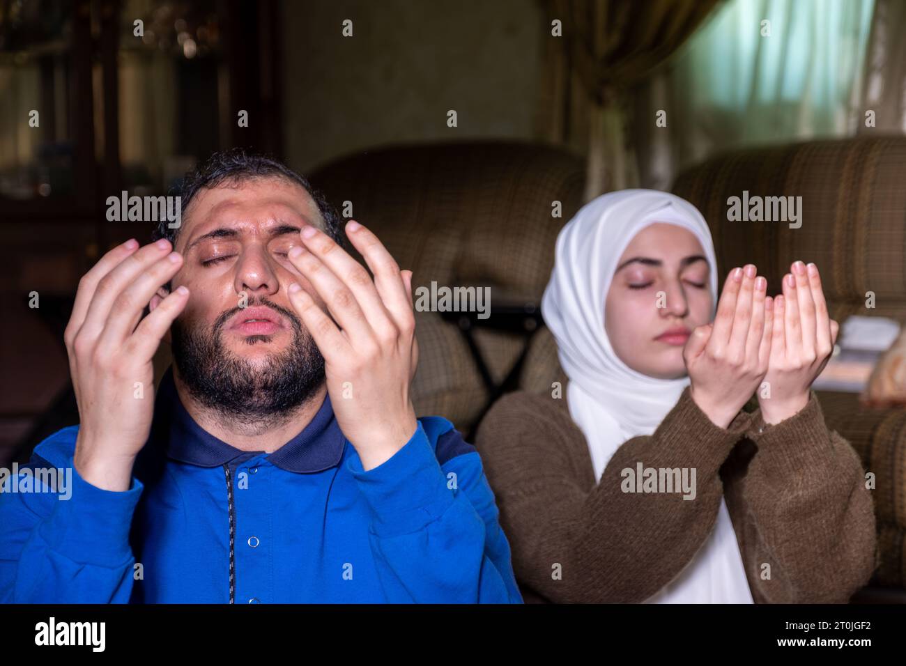 muslimische Paare beten gemeinsam allah um Gnade und Vergebung und tragen lässige Kleidung zu Hause Stockfoto