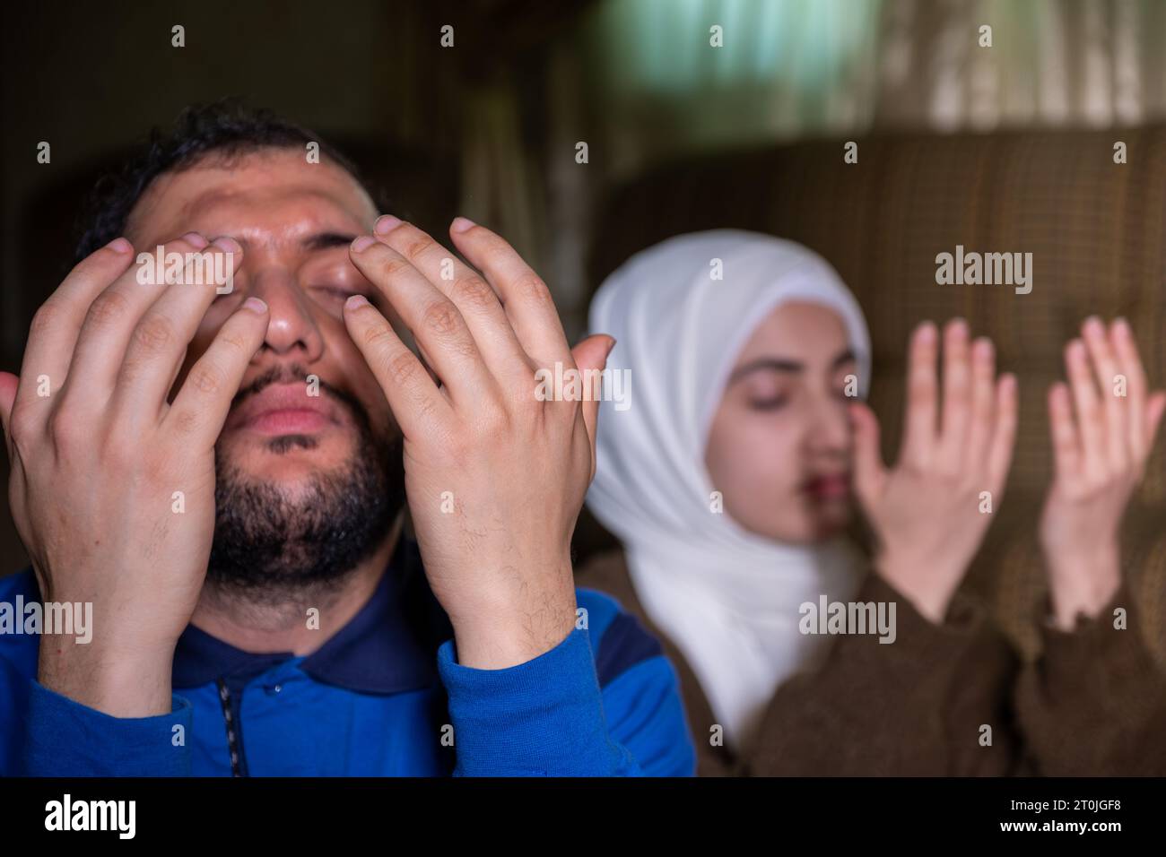 muslimische Paare beten gemeinsam allah um Gnade und Vergebung und tragen lässige Kleidung zu Hause Stockfoto