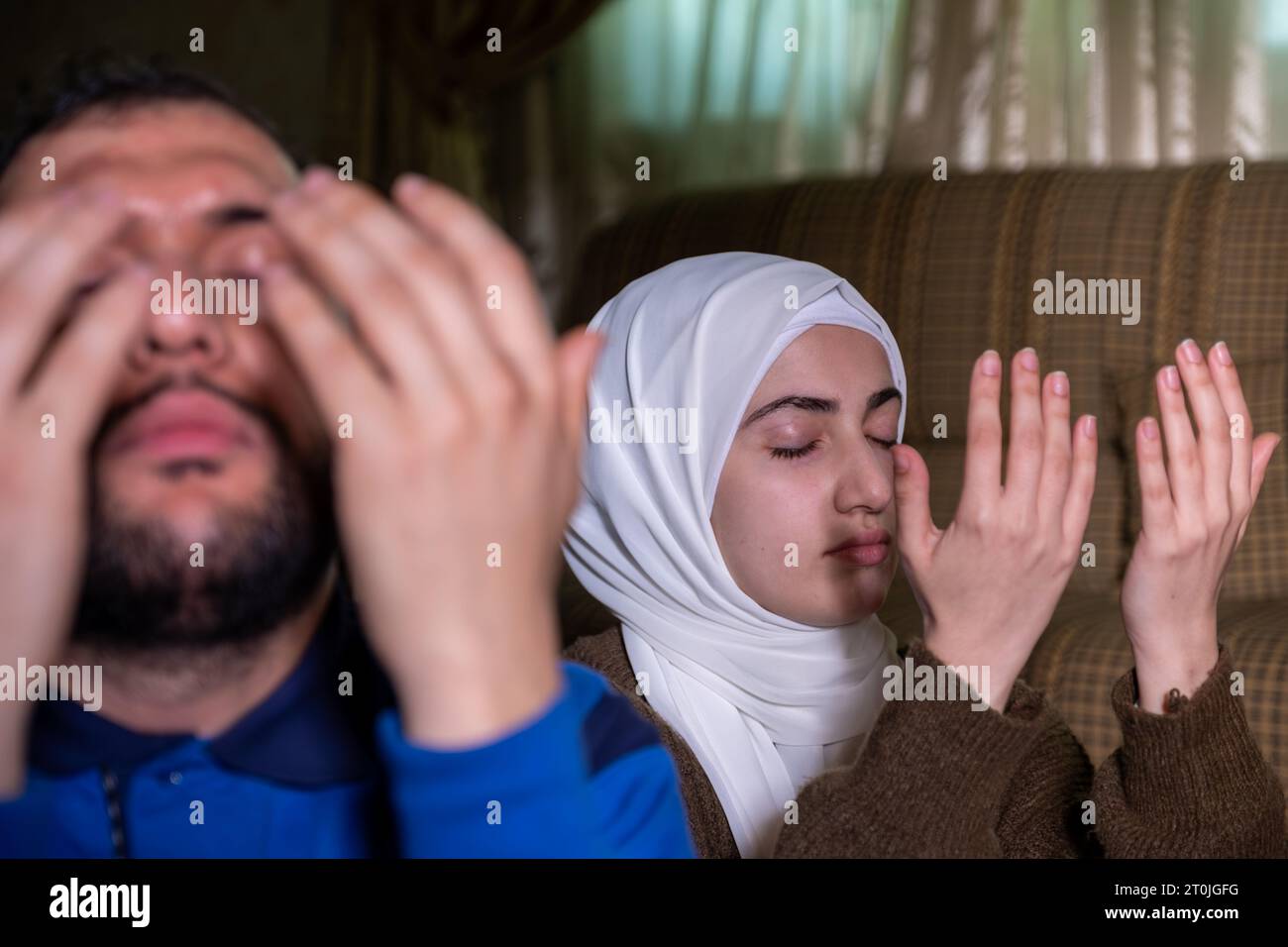muslimische Paare beten gemeinsam allah um Gnade und Vergebung und tragen lässige Kleidung zu Hause Stockfoto