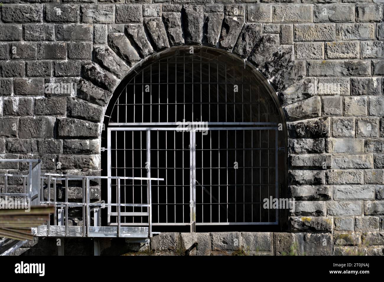 Eintritt zum gruseligen Steintunnel unter dem Wasserdamm Bystricka in Tschechien. Gruseliger dunkler und nasser Ort. Der Eintrag ist nicht zulässig. Stockfoto