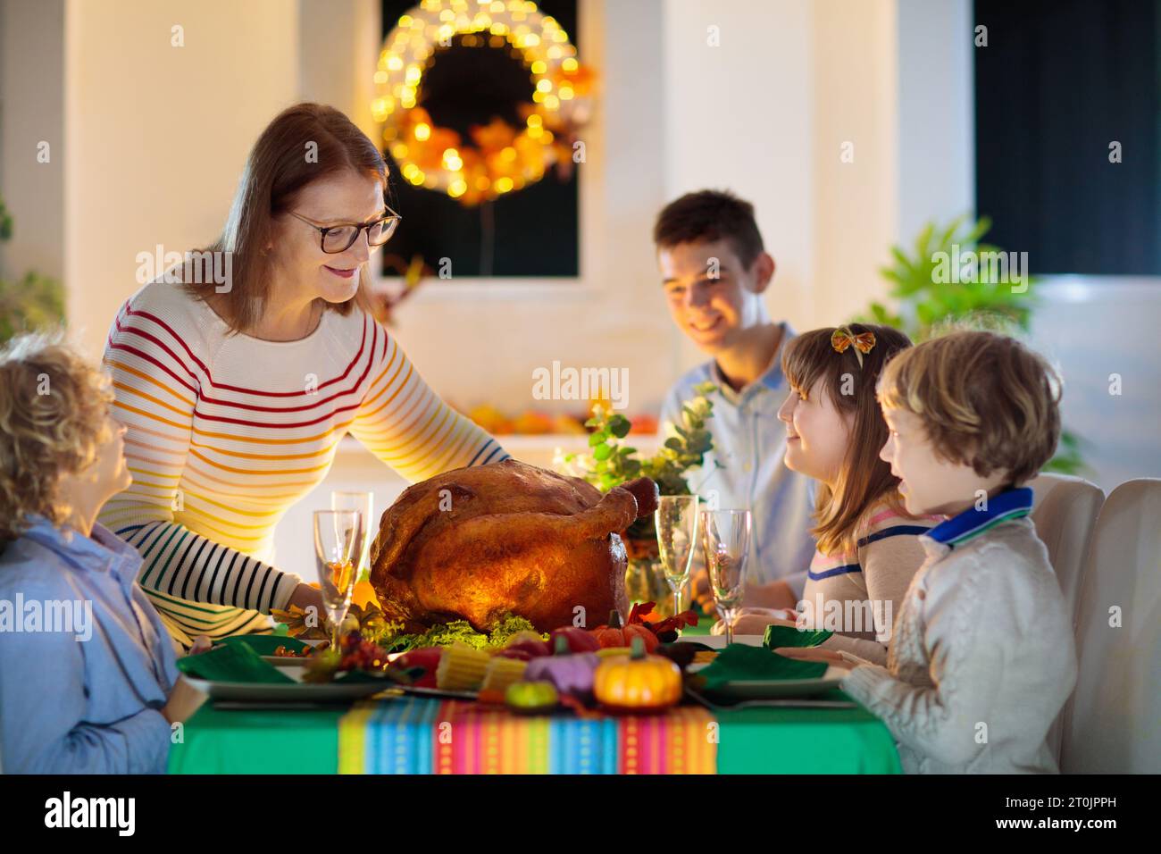 Familie am Thanksgiving-Abendessen. Eltern, Großeltern und Kinder genießen geröstete pute- und Gemüsemahlzeiten. Kinder und Großmutter sagen ein dankbares Gebet. Stockfoto