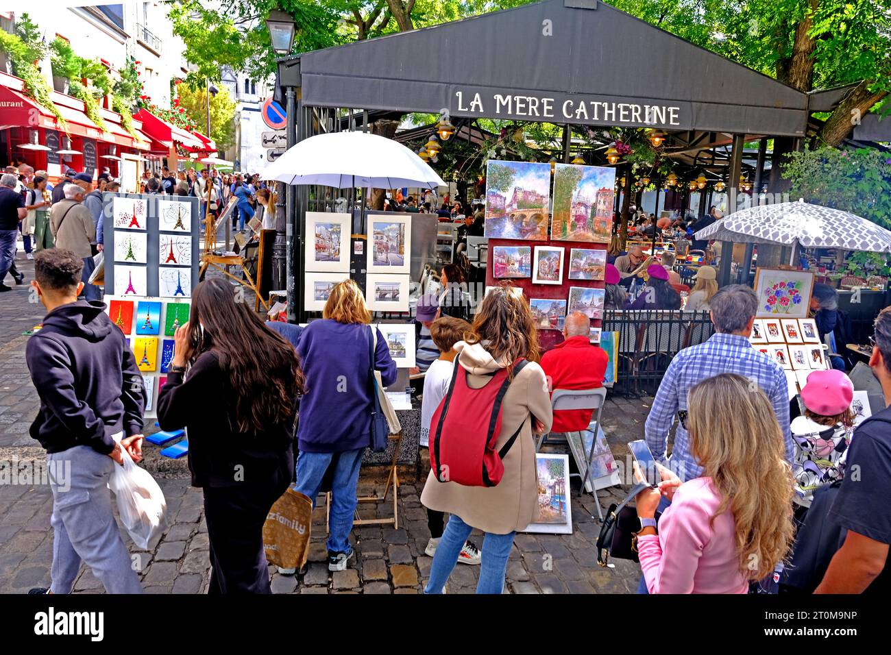 Touristen, die Kunstwerke verschiedener Künstler am Place Tertre im Pariser Montmartre besichtigen Stockfoto