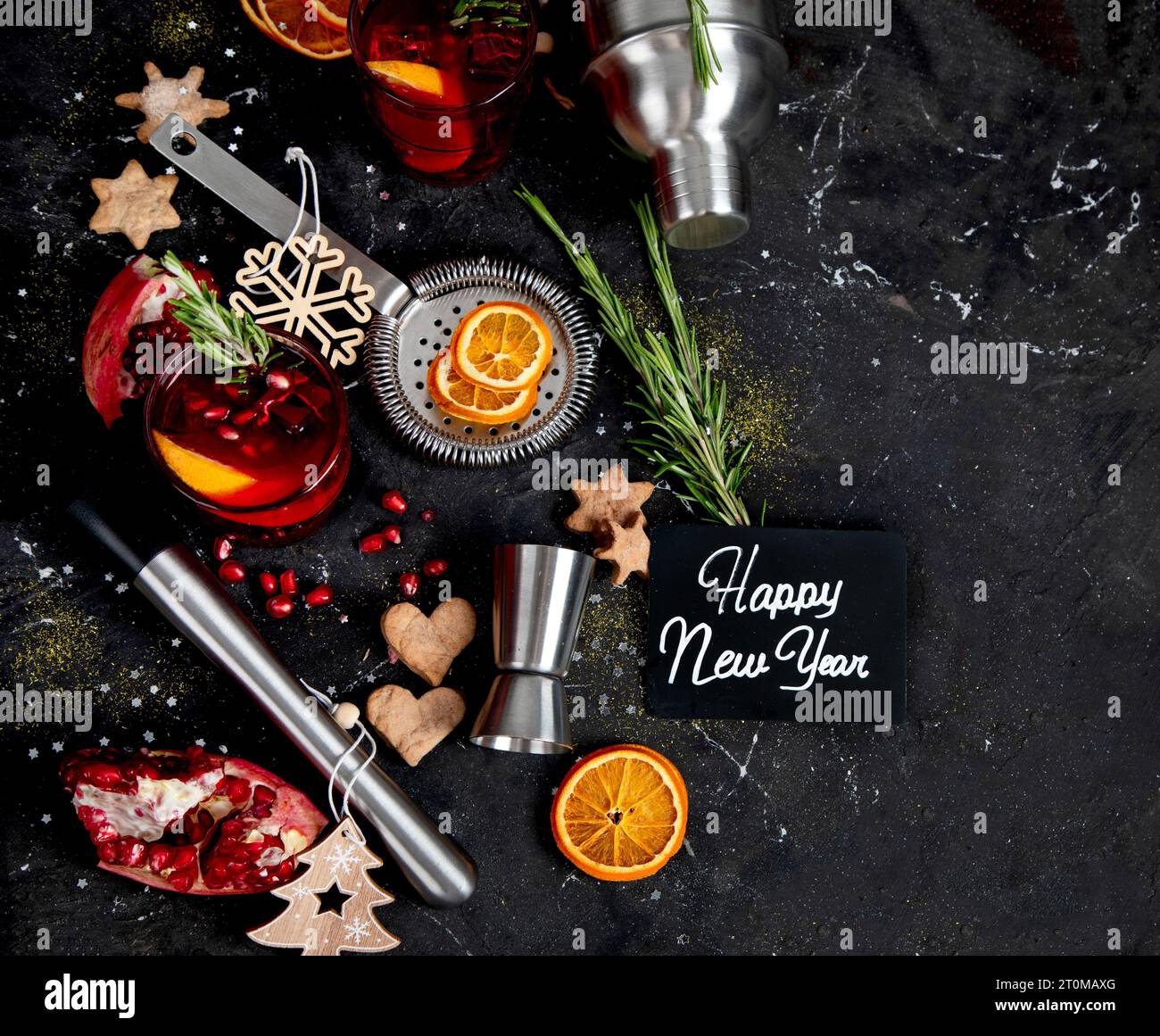 Winter-weihnachtscocktail mit Granatapfel und Rosmarin in einem Glas auf schwarzem Hintergrund. Draufsicht. Stockfoto