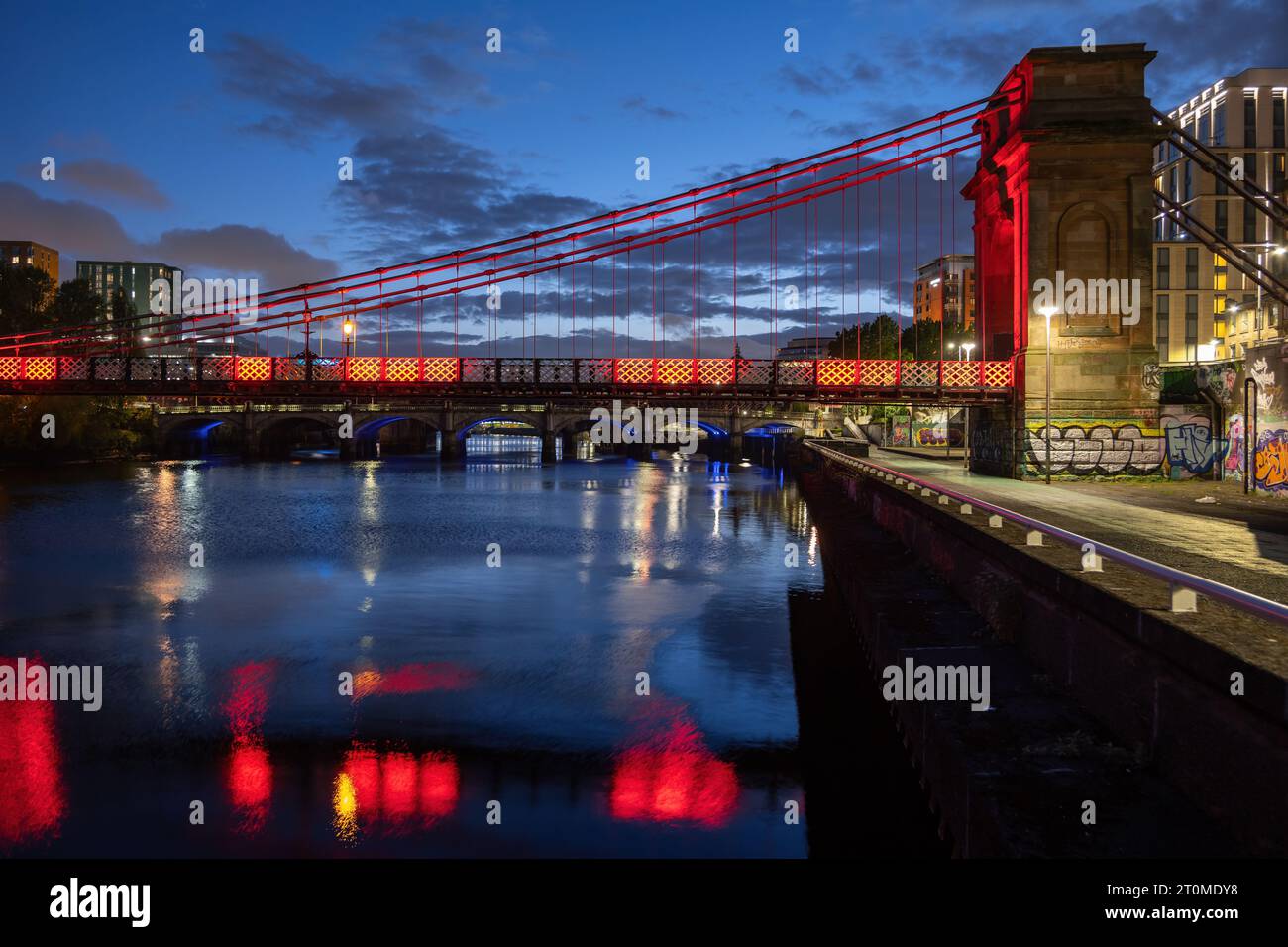 Die South Portland Street Suspension Bridge bei Nacht, Fußgängerbrücke über den Fluss Clyde in Glasgow, Schottland, Großbritannien. Stockfoto