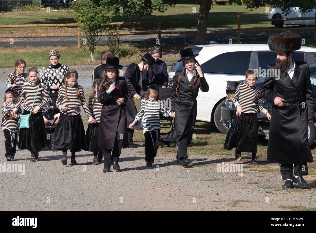 Eine Gruppe ultra-orthodoxer Juden kommt auf einer Farm an, um Sukkos Spaß zu haben. 7 der 14 Menschen tragen dasselbe gestreifte Hemd. In Monsey New York. Stockfoto