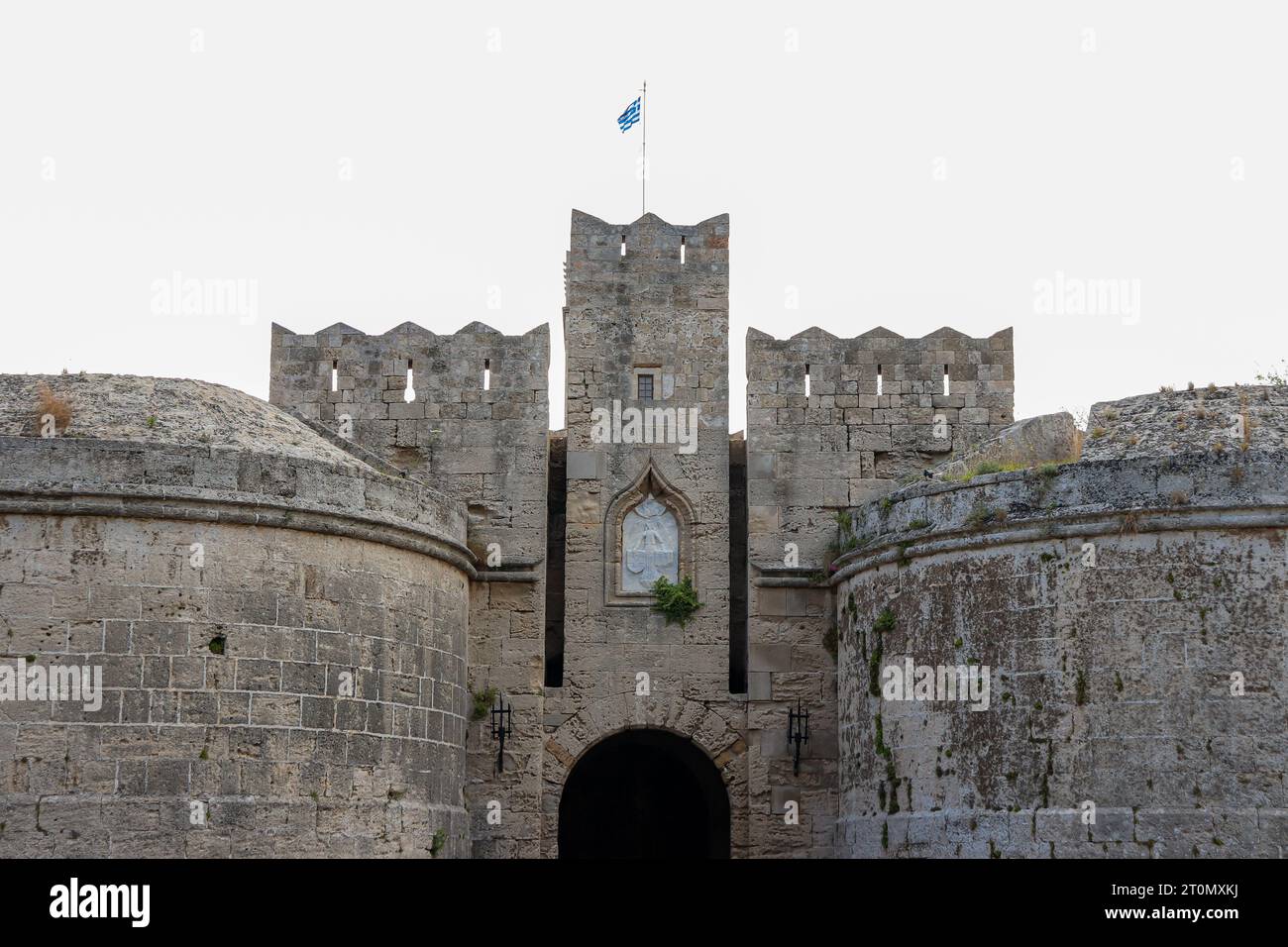 Nahaufnahme des Tors von Amboise in der nordwestlichen Ecke der mittelalterlichen Stadt Rhodos mit griechischer Nationalflagge oben Stockfoto