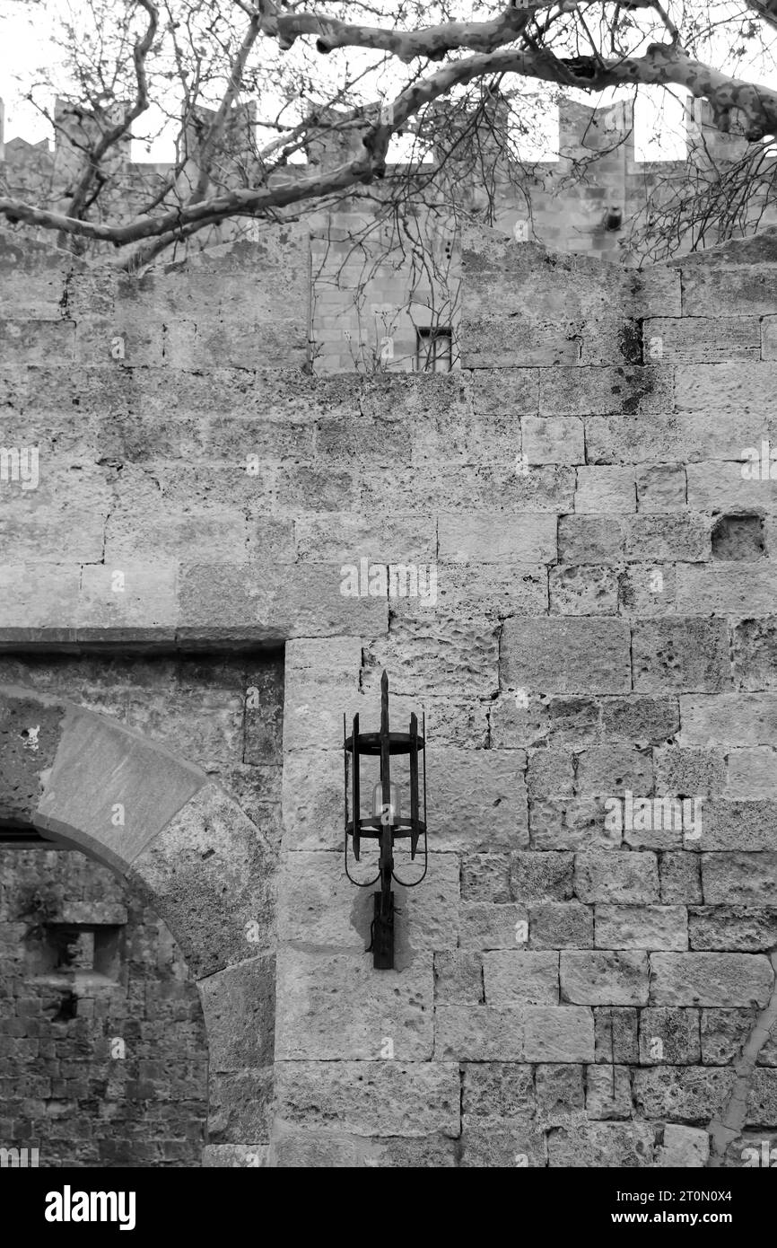 Antike Wandleuchte im mittelalterlichen Stil an den Seiten des Eingangs zum Tor der Altstadt von Amboise Rhodos in Schwarz-weiß Stockfoto Antike Wandleuchte im mittelalterlichen Stil an den Seiten des Eingangs zum Tor der Altstadt von Amboise Rhodos in Schwarz-weiß Stockfoto
