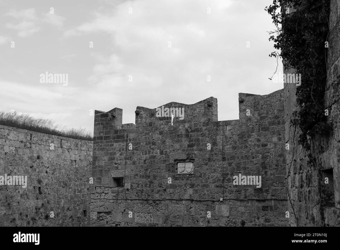Wandfassade der Befestigungsanlagen der mittelalterlichen Stadt Rhodos in Schwarz-weiß Stockfoto