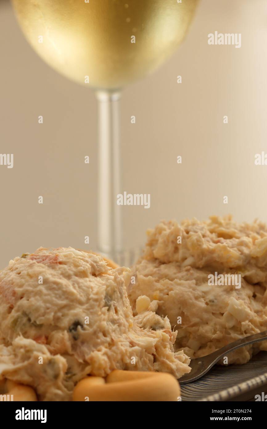 Russische Salatvorspeise mit Brot Donuts begleitet von einem Glas Weißwein Stockfoto