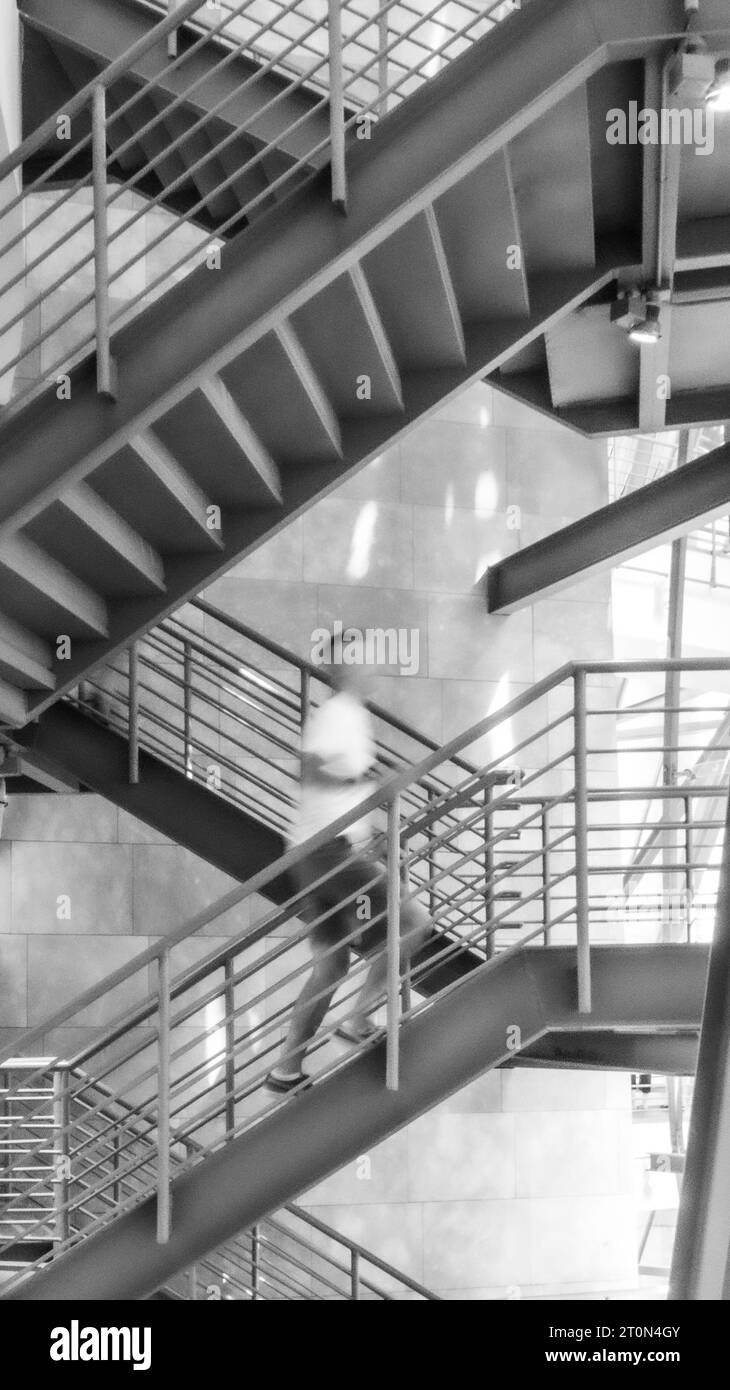 Mann klettert auf die Treppe in einem modernen Gebäude Stockfoto