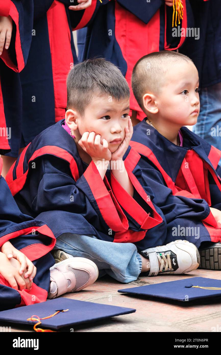 Hanoi, Vietnam. Tempel der Literatur, Van Mieu. Kleiner Junge, der auf ein Abschlussfoto wartet. Stockfoto