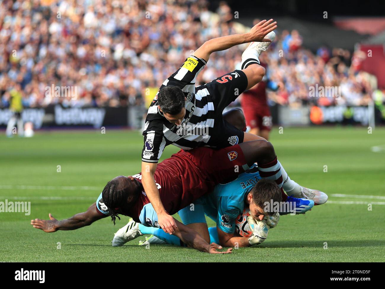 Newcastle United Torhüter Nick Pope (unten) beansprucht den Ball durch den Druck von West Ham United's Michail Antonio (links) und Newcastle United Fabian Schar während des Premier League-Spiels im London Stadium. Bilddatum: Sonntag, 8. Oktober 2023. Stockfoto