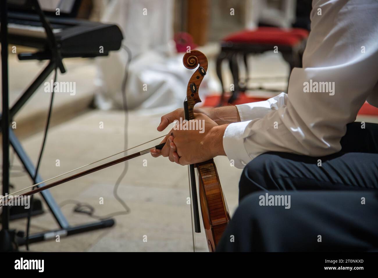 Kaukasischer Geiger, der klassische Kleidung trägt und auf einen Moment wartet, um mit der musikalischen Aufführung zu beginnen. Konzert in einem Innenraum. Nahaufnahme Stockfoto