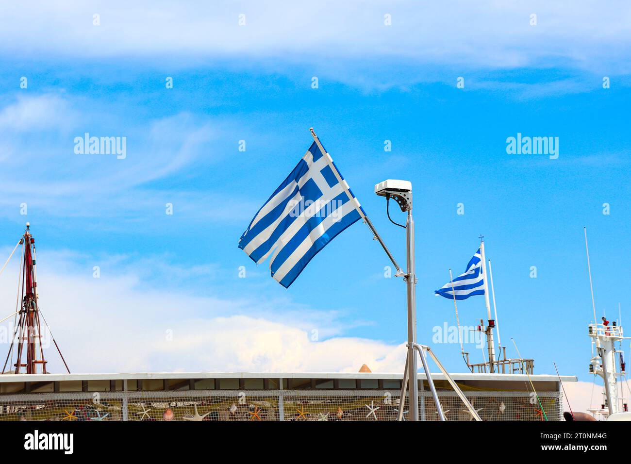 Griechische Nationalflagge auf der Spitze ein nautisches Verkaufsboot, das in Rhodos, Griechenland, angedockt wird Stockfoto