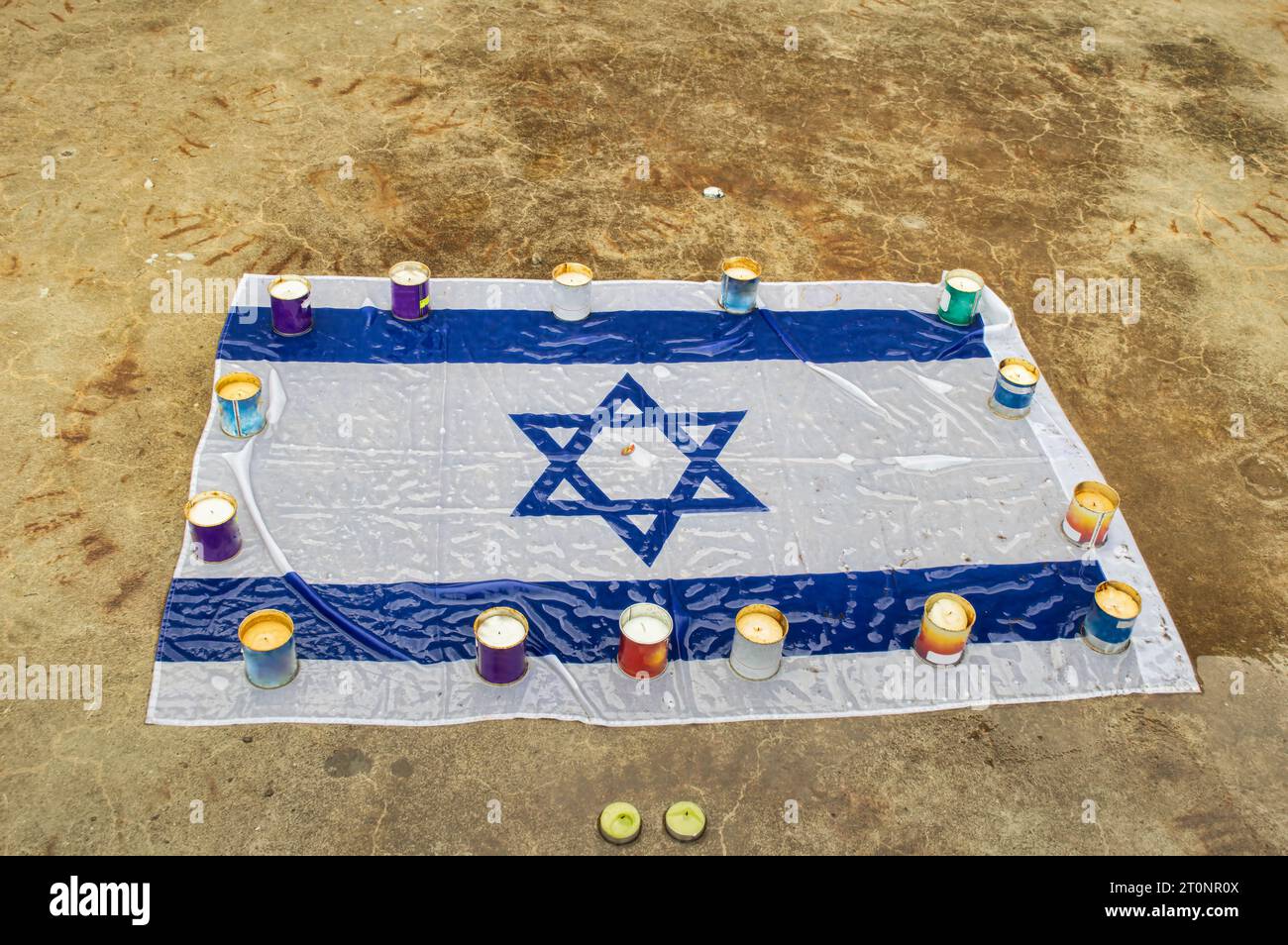 Trauerkerzen brennen auf dem Hintergrund der israelischen Nationalflagge. Holocaust-Gedenktag. Das Konzept des Moments der Stille. Nahaufnahme, Kopierbereich. Stockfoto
