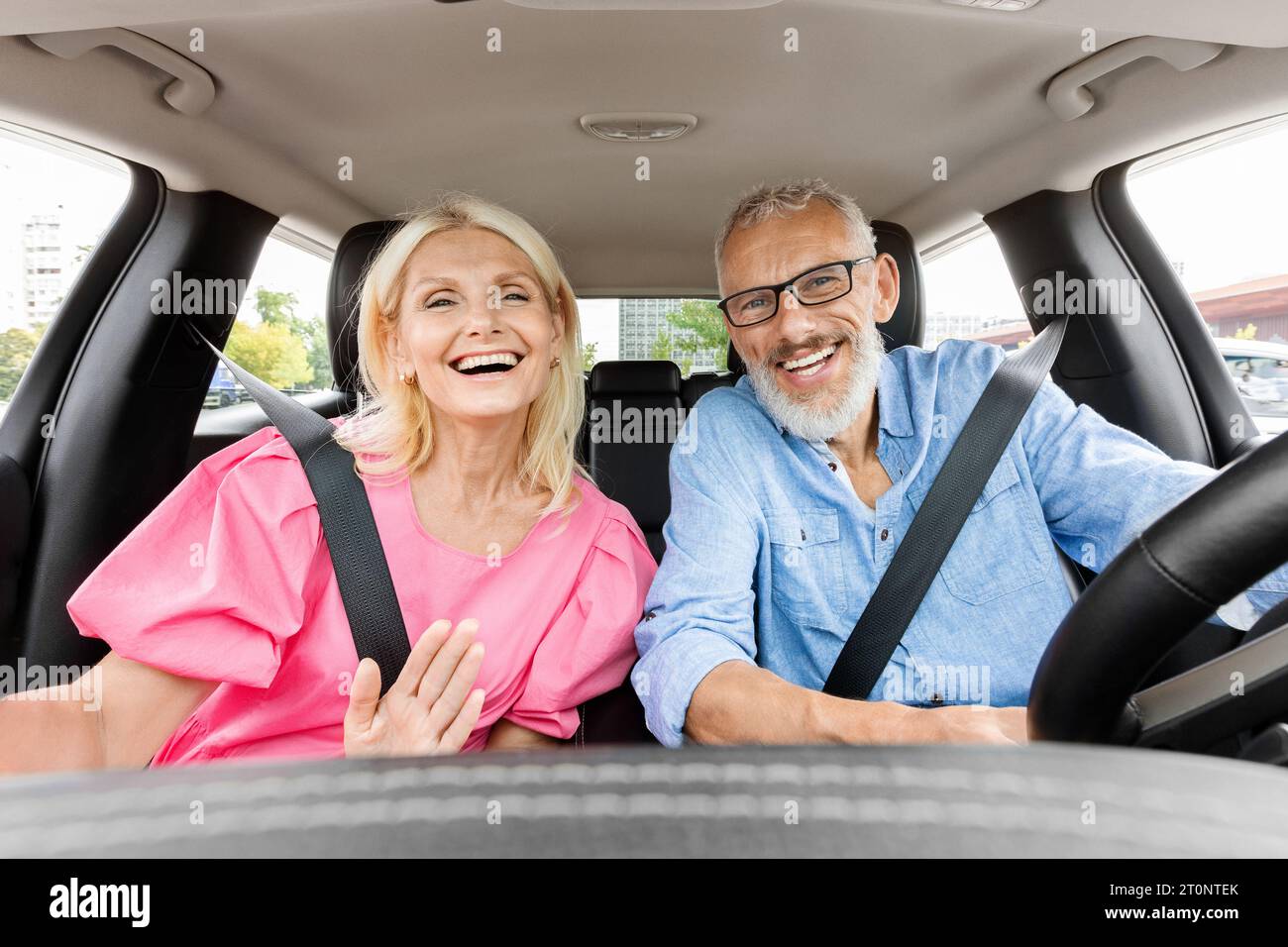 Glückliche ältere Paare fahren mit dem Auto und machen Selfie Stockfoto