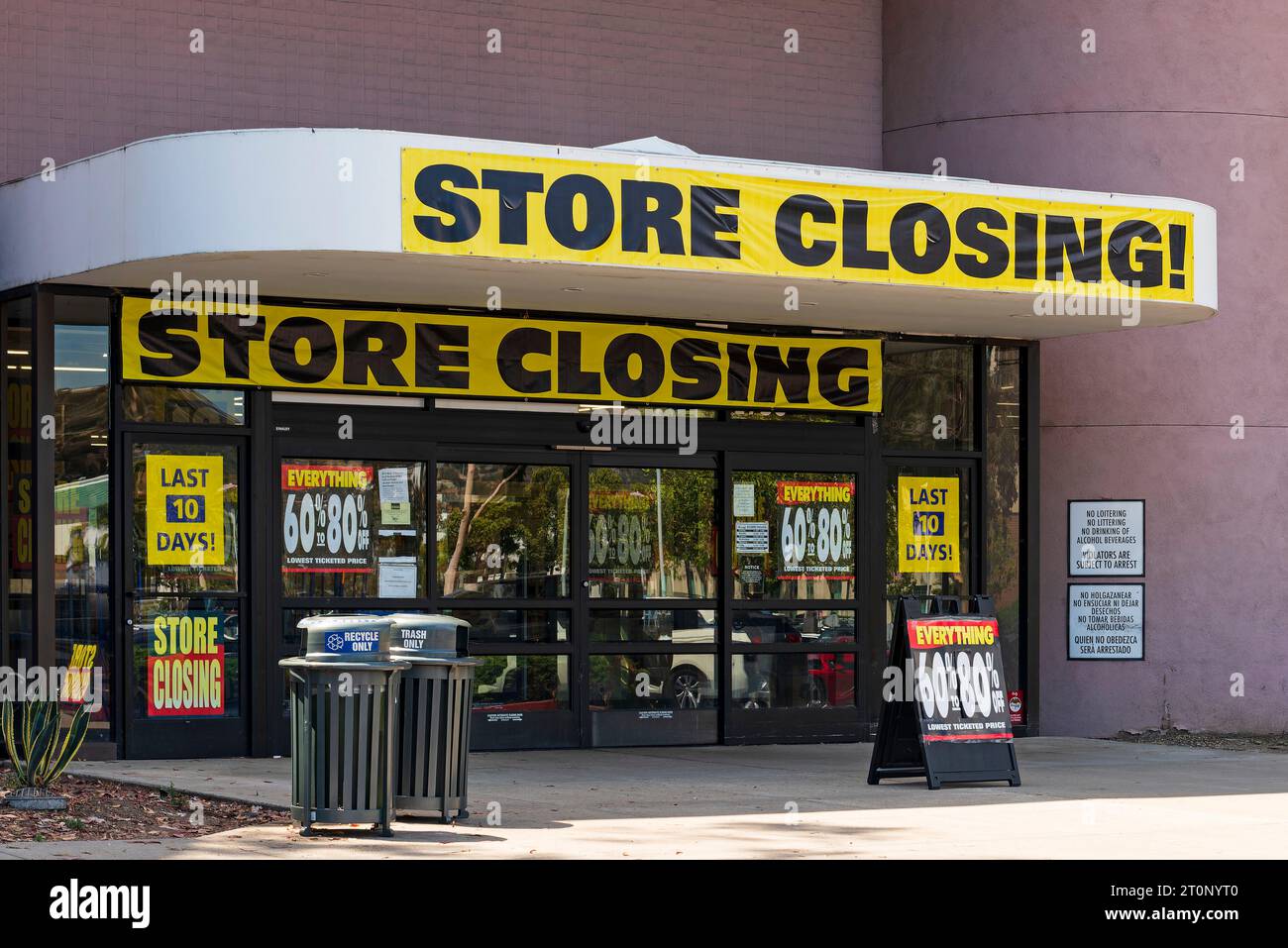Ladeneingang mit Bannern und Schildern zum Schließen des Ladens, die Rabatte für die letzten Tage anzeigen. Stockfoto