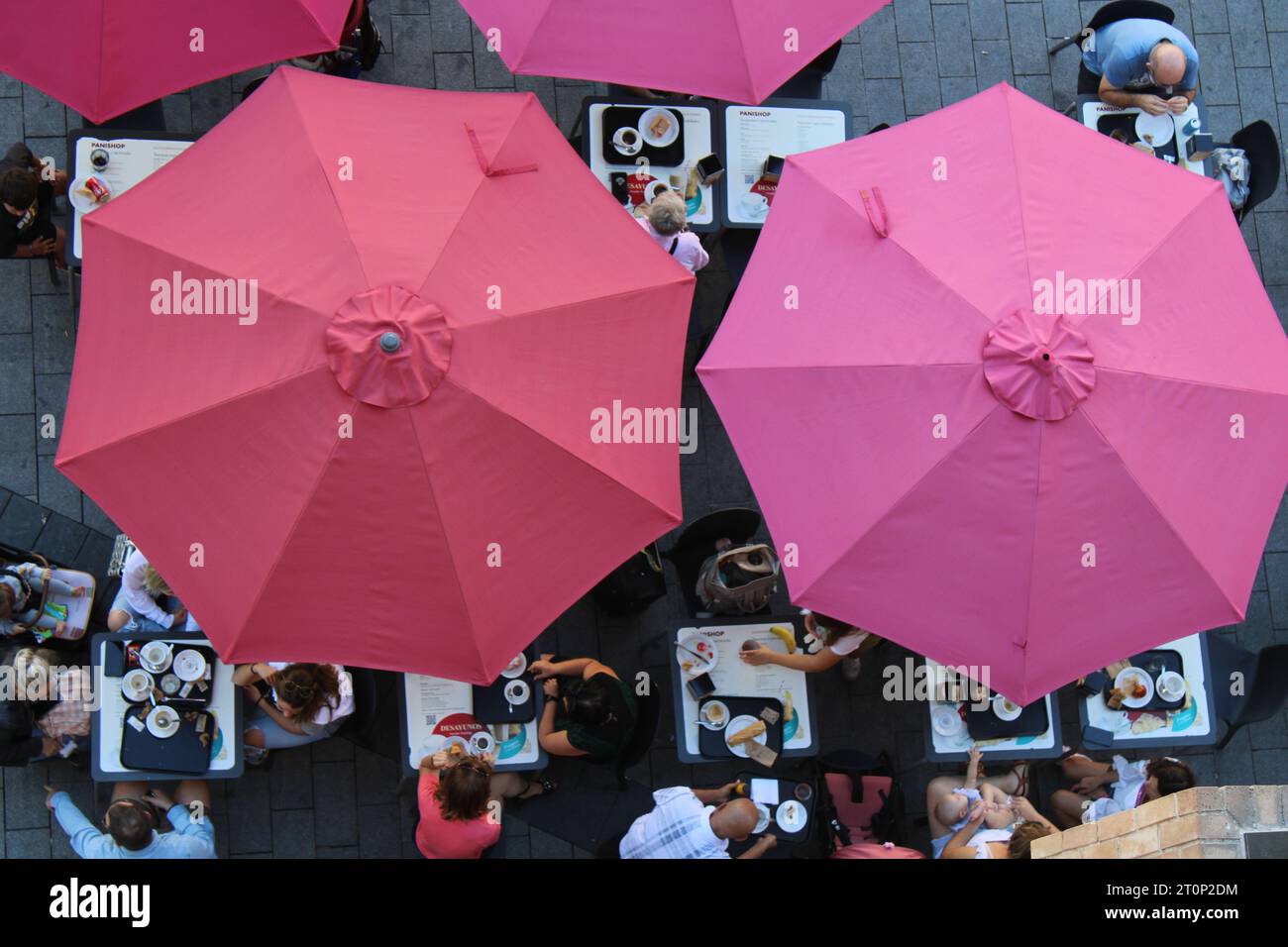 Straßencafé in Tarragona von oben gesehen mit großen rosa Regenschirmen Stockfoto