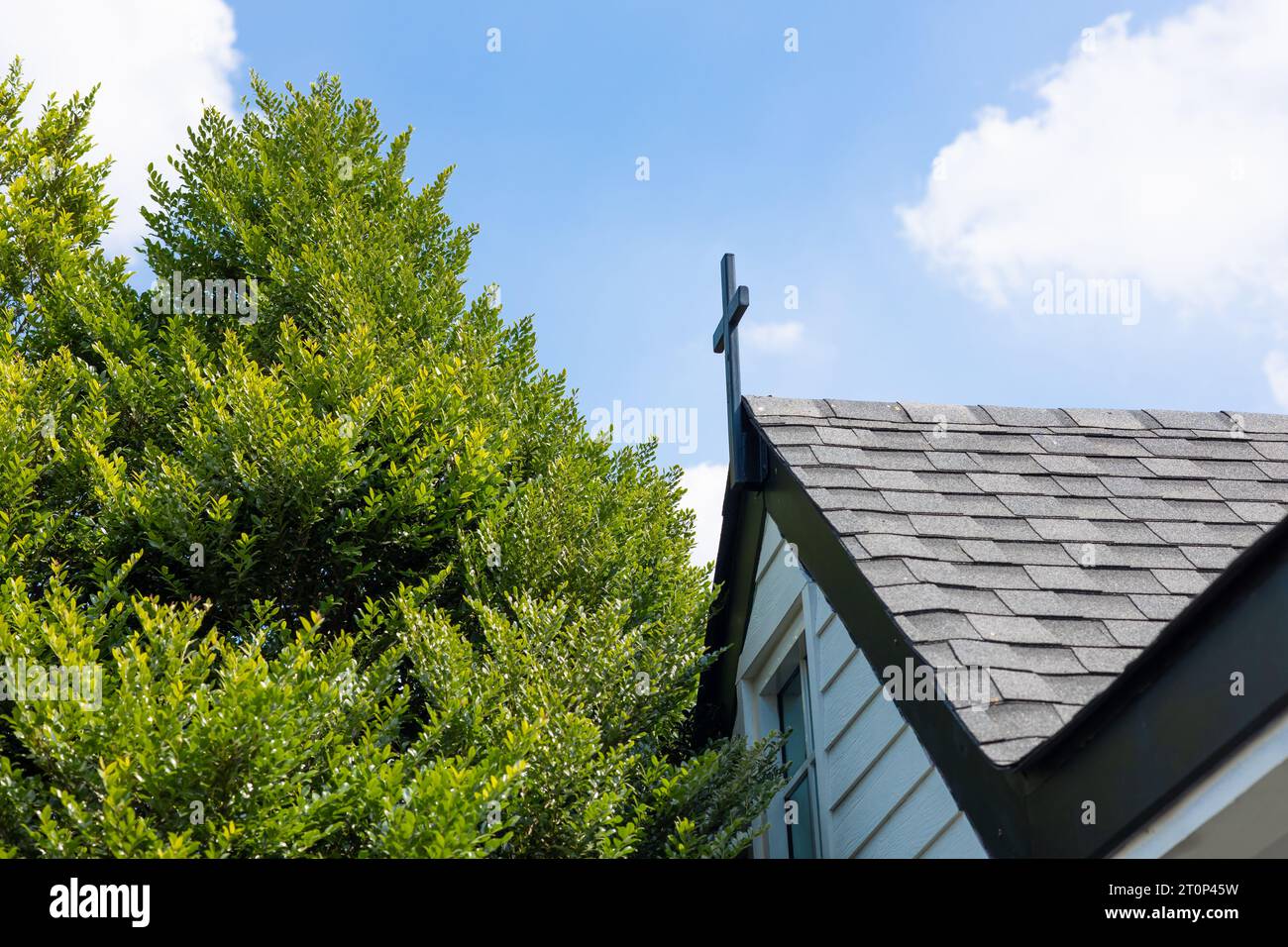 Christ Church modernes Gebäude mit Dachschindeln Material Dachziegel außen mit großen grünen Bäumen Stockfoto