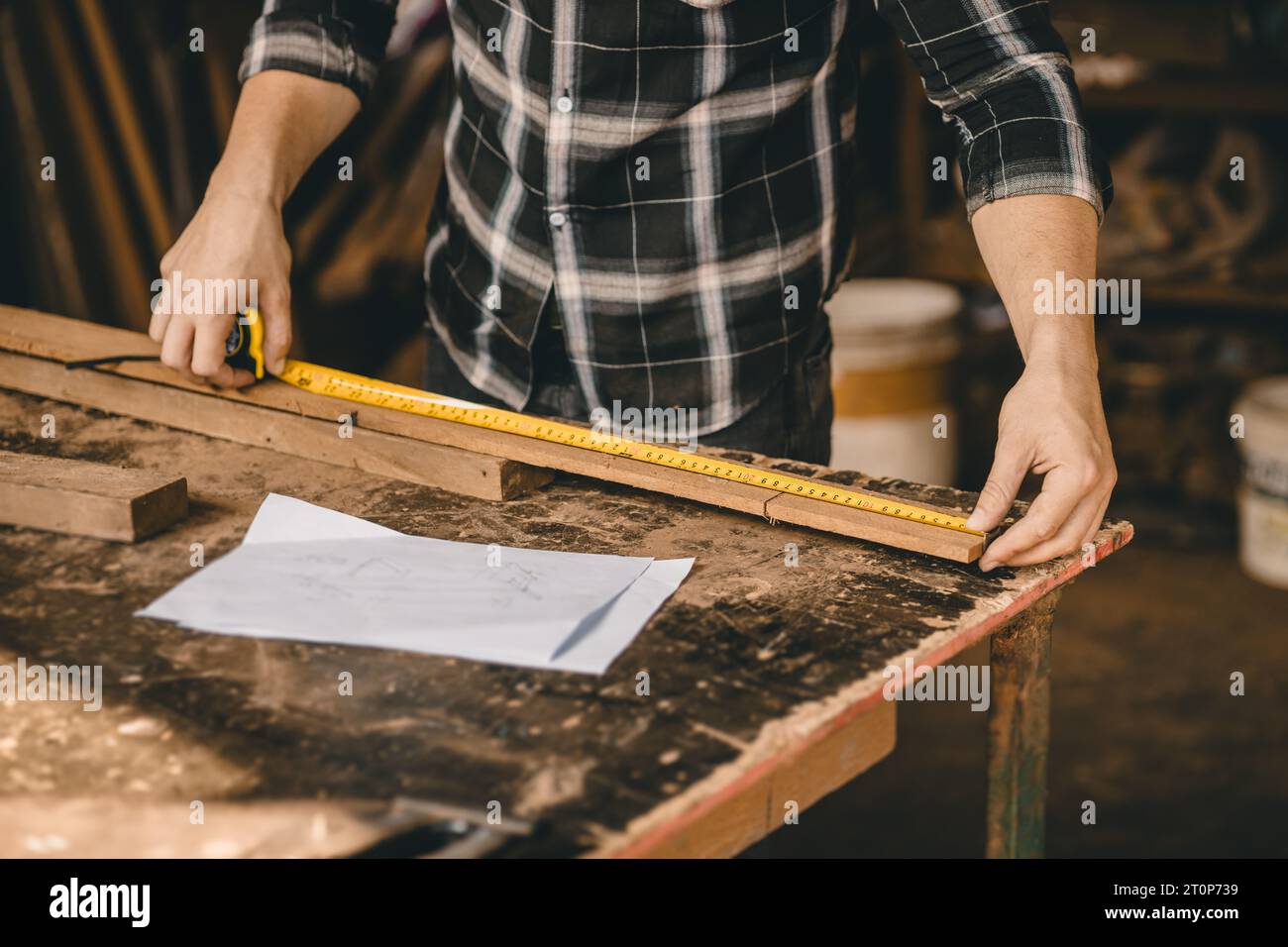 Nahaufnahme Zimmermann männliche Hand Verwenden Sie Maßband Länge des Holzstäbchens für die Herstellung von Möbelprojekten Stockfoto