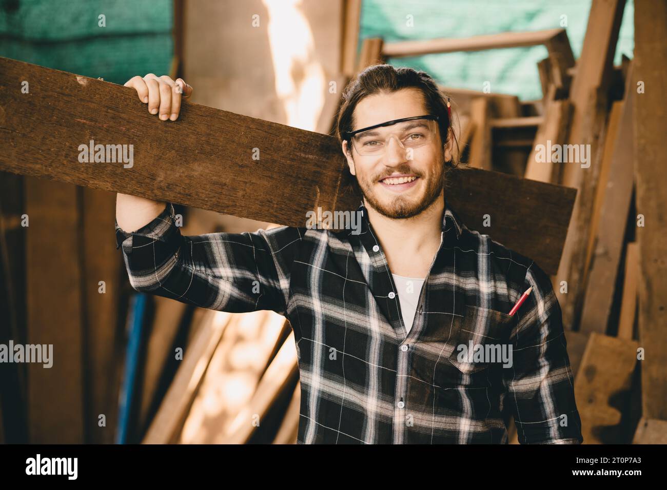 Portrait junger Zimmermann Handwerkerhandwerk Mann mit Holztafel glücklich lächelnd Stockfoto