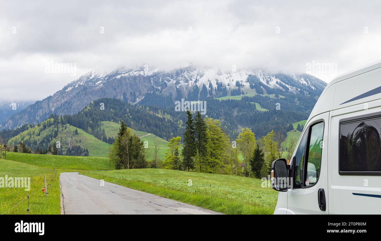 Camperbus mit Panoramablick auf das Emmental und die schneebedeckten Berge im Kanton Bern in der Schweiz Stockfoto