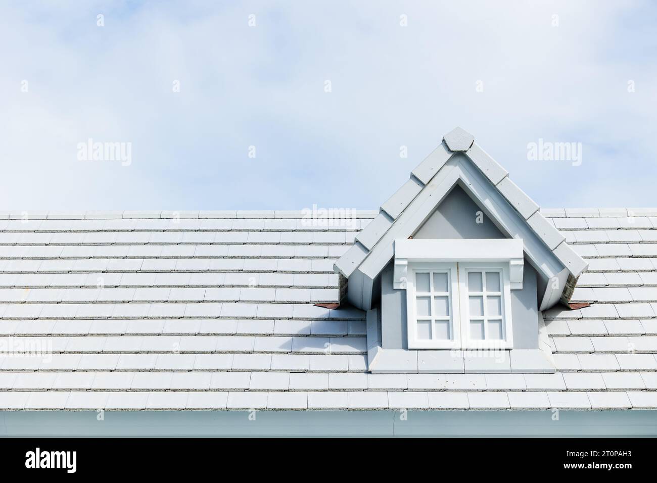 Garret-Zimmer am Schindeldach modernes Asphaltmaterial Dachziegel auf dem Dach des Hauses auf dem Sommer klaren blauen sonnigen Himmel Hintergrund Stockfoto