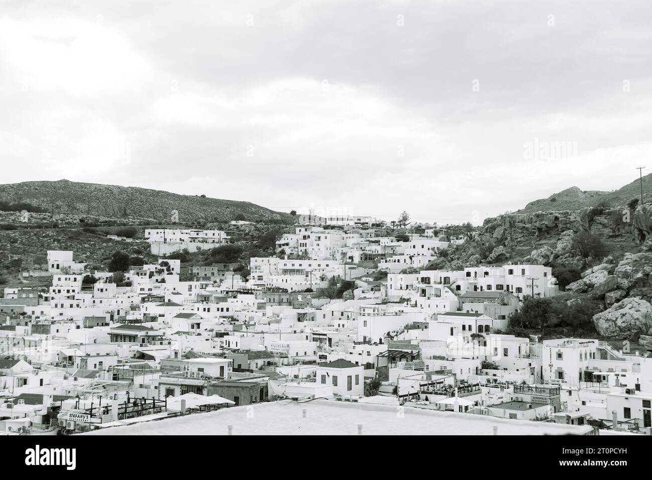 Schwarz-weiß-Blick auf Lindos Stadt, weiße Gebäude von der Akropolis der Festung Lindos auf einem Berg Stockfoto