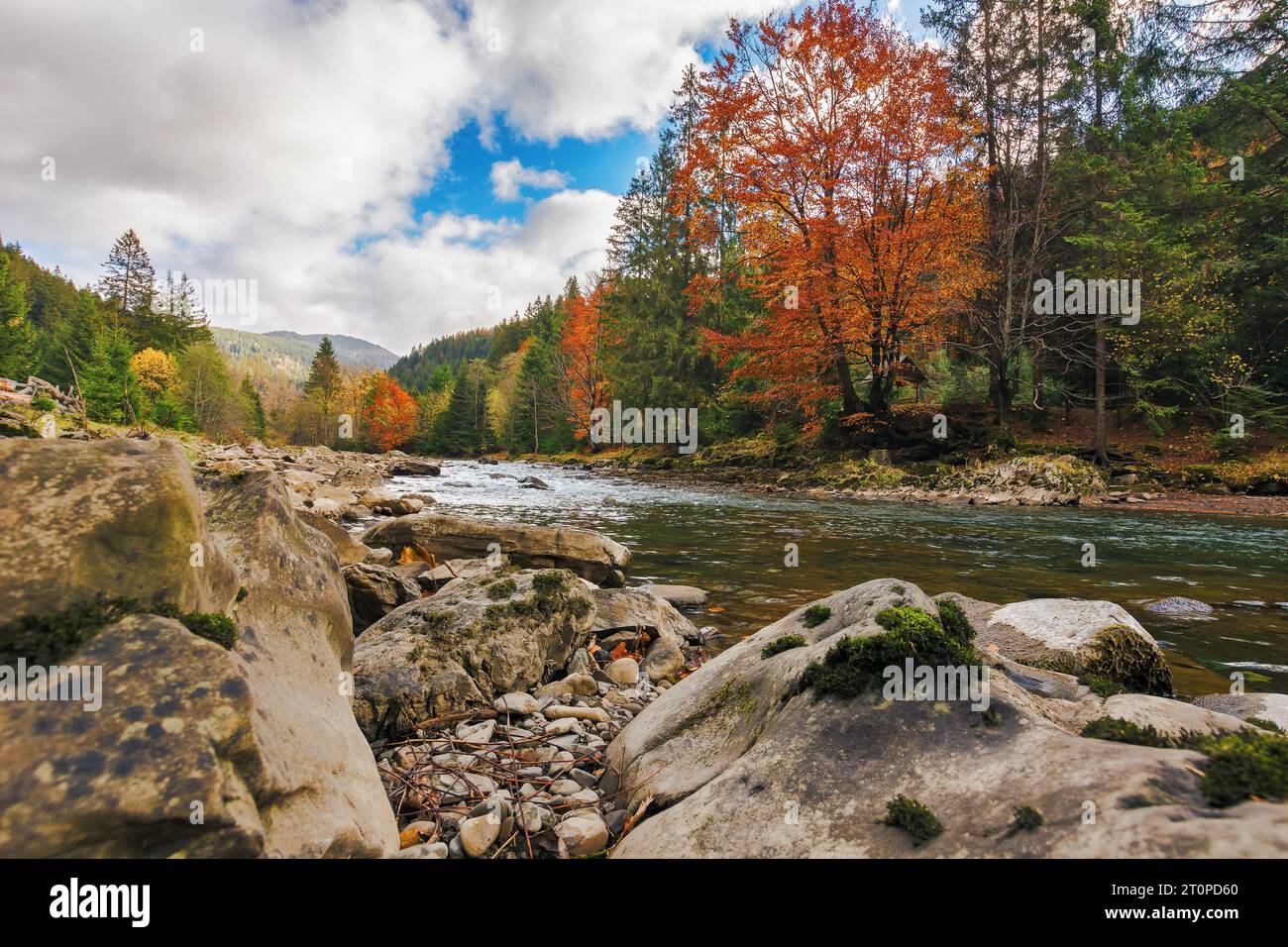 Landschaft mit Steinen und Felsen am Ufer eines Flusses. Herbstlandschaft in Bergen mit bewölktem Himmel Stockfoto