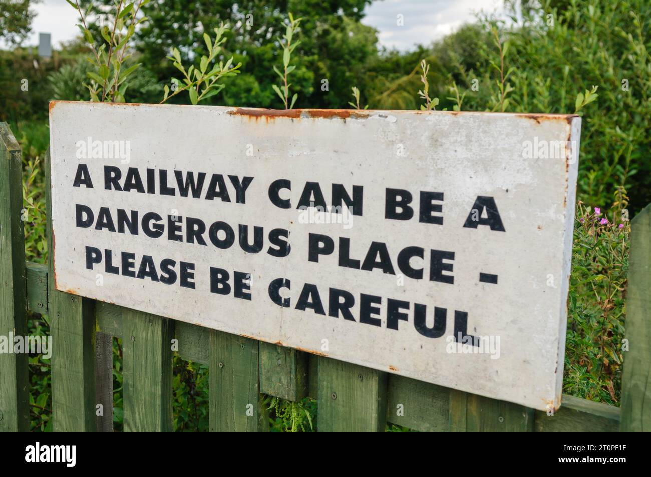Schild Warnung Passagieren und Besuchern, vorsichtig zu sein in der Nähe von Gleisanlagen Stockfoto