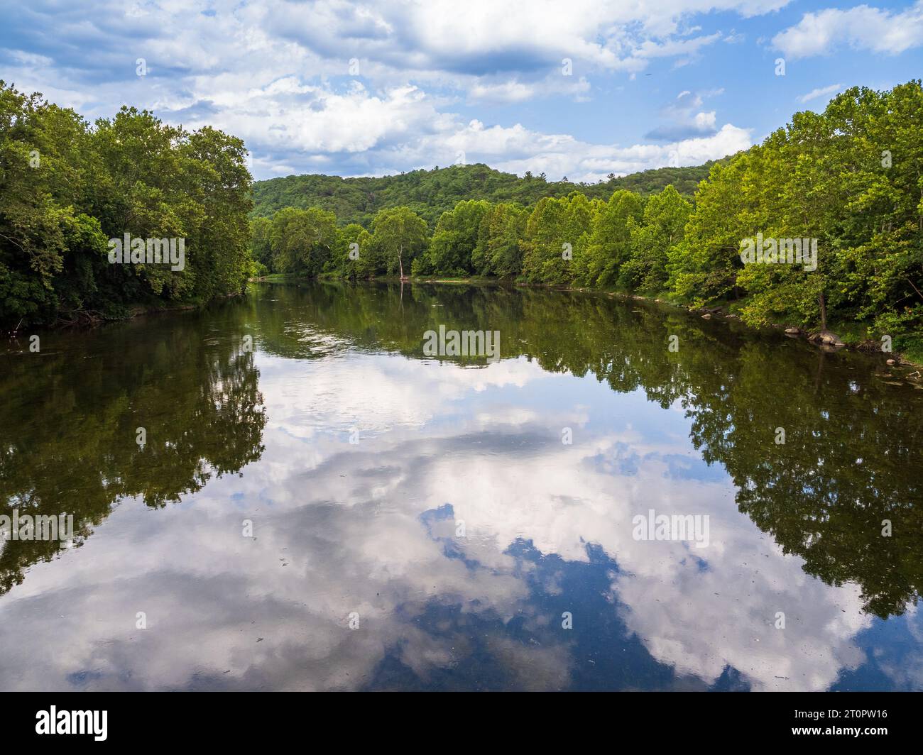 Das ruhige Wasser des South Fork des Shenandoah River in Virginia, USA, spiegelt die umliegenden Bäume, den Himmel und die Wolken wider. Stockfoto