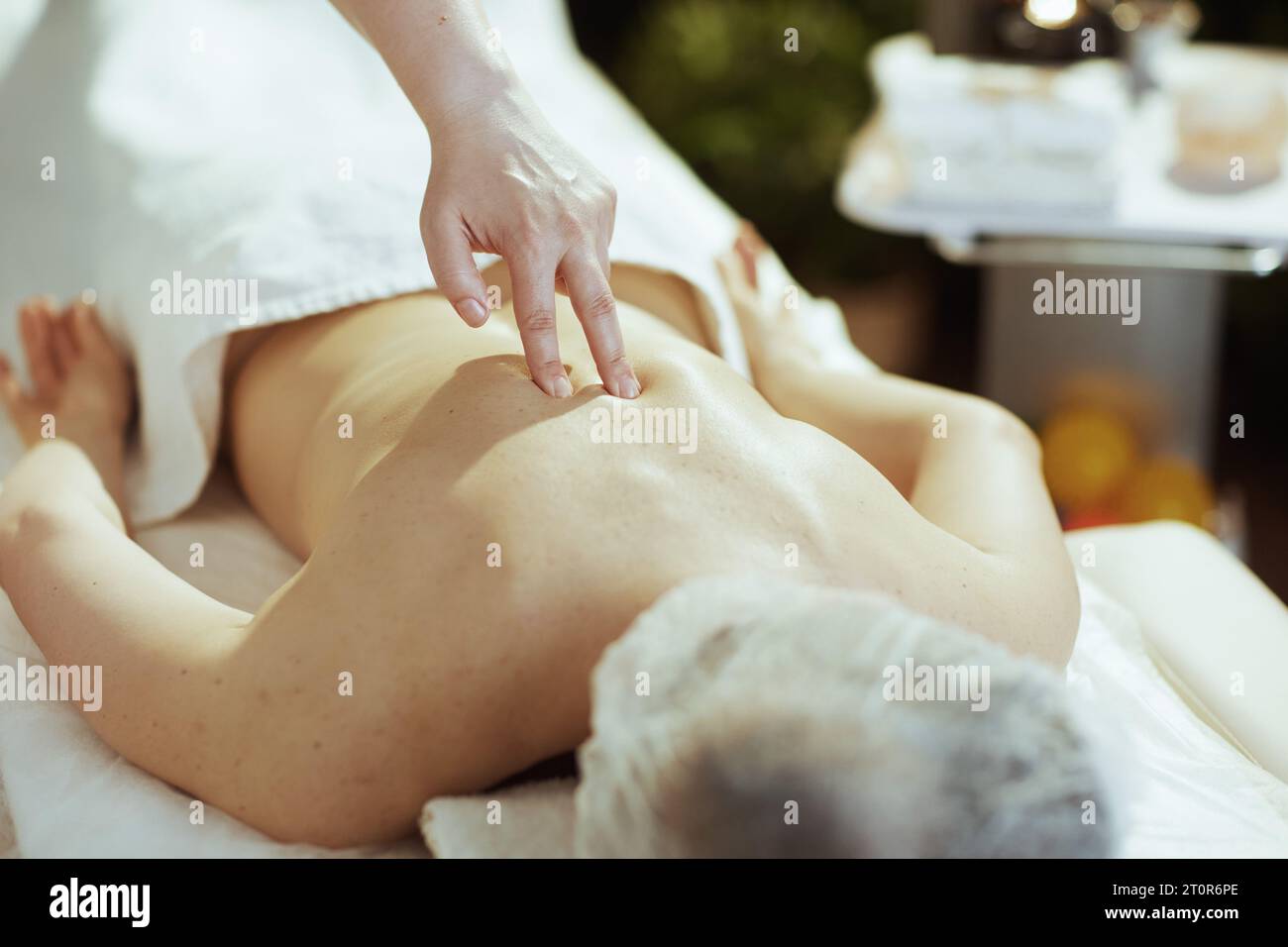 Gesundheitszeit. Nahaufnahme eines medizinischen Massagetherapeuten im Massageschrank, der Klienten zurück massiert. Stockfoto