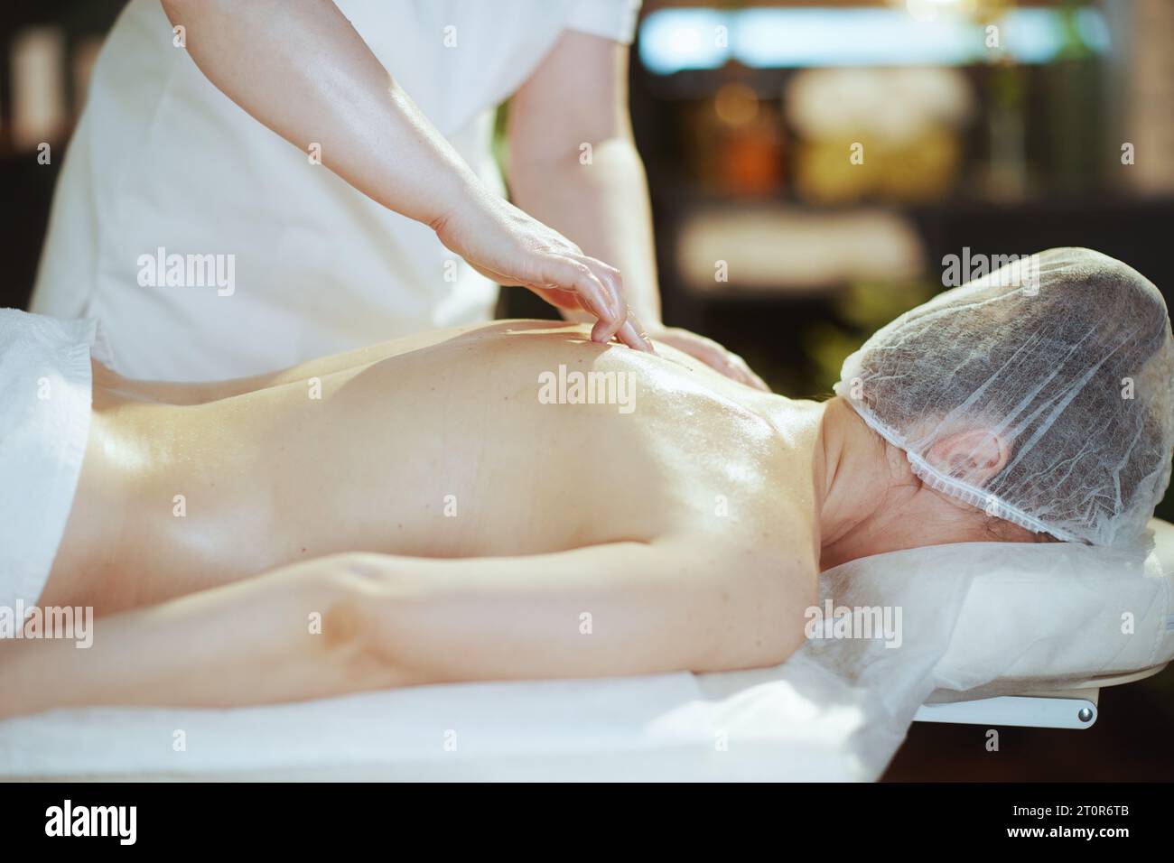 Gesundheitszeit. Massagetherapeut im Spa-Salon machen eine therapeutische Massage auf dem Massagetisch. Stockfoto