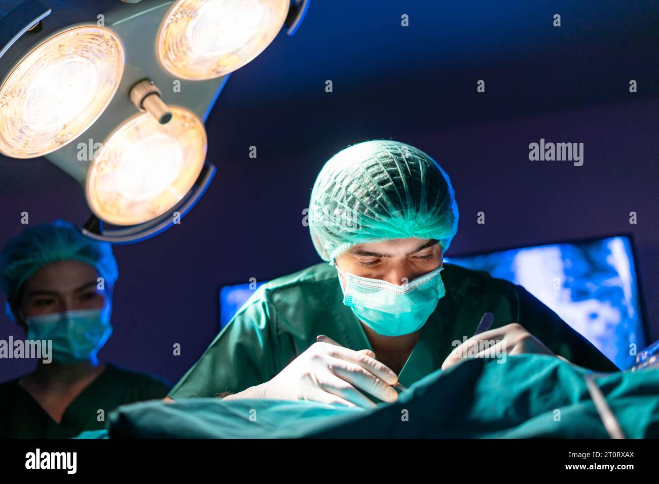 Ärzte während der Operation im Krankenhausoperationssaal mit Patienten. Virtuelle Chirurgie-Simulation Stockfoto