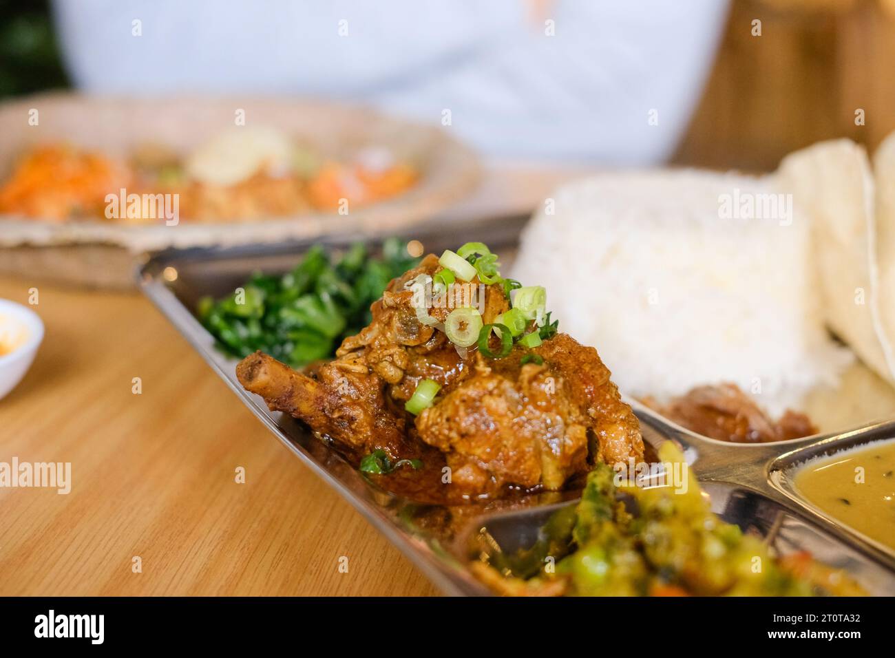 Chicken Daal Baht Power (Reis, Spinat, Linsen, Gurke & Hühnercurry) serviert auf einem Edelstahltablett in einem nepalesischen Restaurant in Sydney Stockfoto