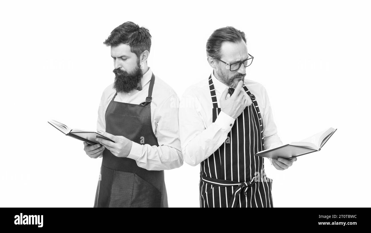 Wie man kocht. Männer bärtigen Hipster kochen Schürze Lesen Bücher über kulinarische. Keine Ahnung, wie man Essen kocht. Kulinarisches Buchkonzept. Männer, die den Haushalt führen. Einige Stockfoto